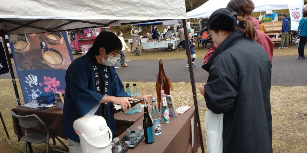 いむた池マルシェに参加する祁答院蒸溜所ブース。試飲の様子。